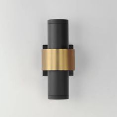 a black and gold wall light on a white wall with no one around the lamp