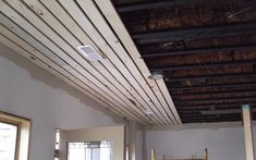 an unfinished room with wood slats on the ceiling