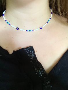 a woman wearing a black top and a necklace with blue beads on the bottom of her neck