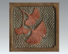 a decorative tile with two leaves on it