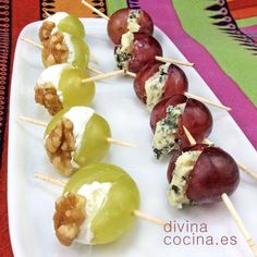 grapes are arranged on skewers with cheese and walnuts