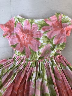 "This lovely sundress is all sweetness and sunshine. Pinks and greens are such a great combination! I loveeeee the pink mother of pearl buttons! Bust 36\" Waist 26\" Length 38\" This item is clean and ready to wear. Comes from a smoke and pet free home. Don't forget to follow me on Instagram @tammaraclearshercloset for new listing alerts. This is shipping from Singapore. Standard post takes about 10 working days. Please contact me if you need it urgently. H151" Pink Tea Length Summer Dress, Pink Tea-length Summer Dress, 1950s A-line Vintage Summer Dress, Summer Dresses With Box Pleat And Full Skirt, 1950s Style Summer Dress With Short Sleeves, Green Full-skirt Summer Dress, Green Full Skirt Summer Dress, Green Full Skirt Dress For Summer, Pink Summer Dress For Vintage Occasions