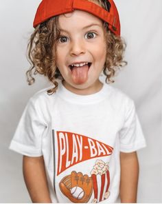 Gear up your little one for game day with our Play-Ball Toddler's Tee! This baseball-inspired t-shirt is the ultimate addition to any sports enthusiast's wardrobe. Whether you're cheering from the stands or hitting the field yourself, our tee is designed to keep you comfortable and stylish all season long. Classic fit Tear-away label Runs true to size 🪄 We are able to design and CUSTOMIZE! See a product, but want to personalize the text or color? We collaborate closely with you to design tailor White Crew Neck T-shirt For Playtime, Cotton Tops For School Spirit Playtime, Fun White Sports T-shirt, Fun Sports T-shirt With Letter Print, Fun Game Day Top With Screen Print, Fun Screen Print Tops For Game Day, Fun Screen Print Top For Game Day, Fun Red T-shirt For Playtime, Sporty Pre-shrunk T-shirt For Game Day