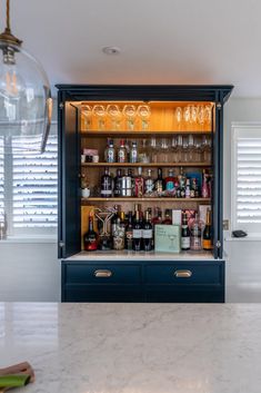 a bar with wine glasses and liquor bottles on the shelves in front of it's doors