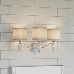 two lamps mounted on the wall above a mirror