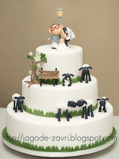 a wedding cake decorated with figurines of sheep and a man on a bench