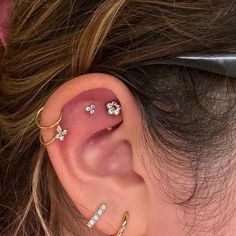 a woman's ear with three different types of piercings