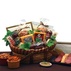 an assortment of meats and cheeses in a basket on a table with other foods