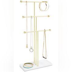 a gold jewelry rack with three necklaces and two rings hanging from it's sides