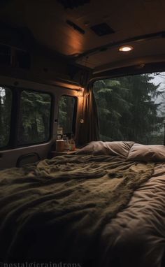 an empty bed in the back of a van with trees out front and lights on