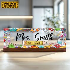 a wooden sign that says, mr smith 1st grade with school supplies around it on a table