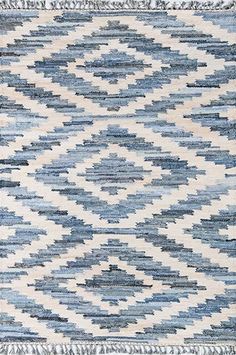 a blue and white rug with fringes on it