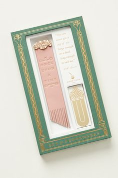 two pink and gold hair combs in a green box