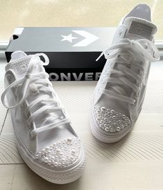 a pair of white sneakers sitting on top of a box