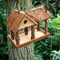 a wooden bird house hanging from a tree