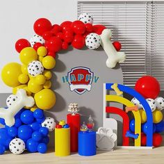 balloons and decorations are displayed in front of a party arch for a child's birthday