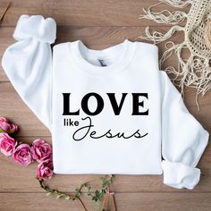 SIZES ARE TRUE FIT, ORDER A SIZE OR TWO BIGGER FOR LOOSE FIT. Especially if you're going for that trendy oversized look. Introducing the "Love Like Jesus" Sweatshirt: A Cozy Expression of Faith and Compassion Embrace comfort and share a powerful message with our "Love Like Jesus" sweatshirt. Designed to inspire and remind us to lead with love and grace, this sweatshirt is perfect for anyone who wants to express their faith while staying stylish and comfortable. Whether you're out and about or re White Letter Print Sweatshirt For Gift, White Letter Print Sweatshirt As Gift, Long Sleeve Sweatshirt With Lettering As Gift, White Letter Print Sweater As Gift, Long Sleeve Slogan Tops As Gifts, Boutique Supplies, Bible Verse Aesthetic, Verse Aesthetic, Christian Sweatshirts