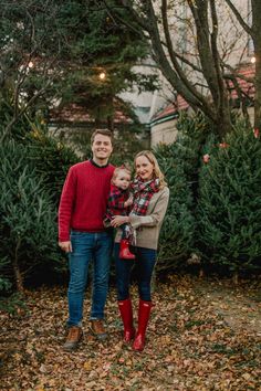 a man and woman standing in front of christmas trees with red boots on their feet