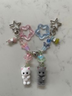 the keychain is decorated with different colored beads and charms, including a cat