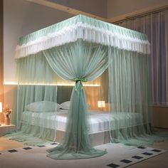 a canopy bed with sheer curtains on the top and bottom, sitting in a bedroom