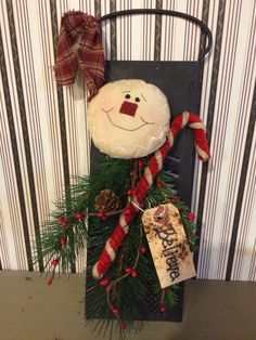 a snowman decoration hanging from the side of a door with christmas decorations on it