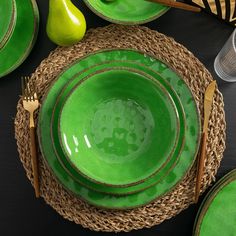 a table set with green plates and silverware