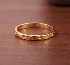 a close up of a gold ring on a wooden table