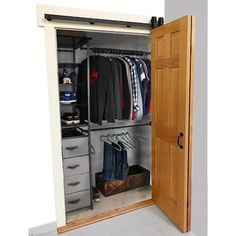 an open closet with clothes and suitcases in it