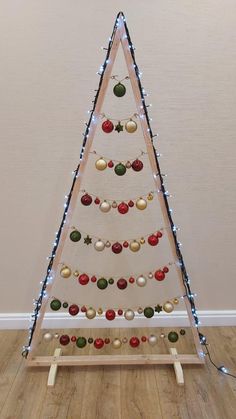 a christmas tree made out of wood and decorated with ornaments on it's sides