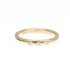 a yellow gold ring with three diamonds on it