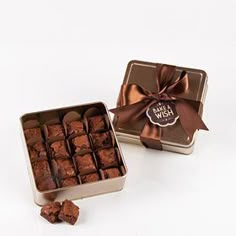 a box of chocolates with a ribbon around it and some pieces in the middle