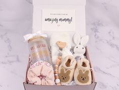 a baby gift box with shoes, rattlers, pacifier and other items in it