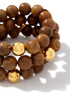 Include us in your adventures wearing this stacked piece comprised of three 'stretchy' strands of sandalwood wooden beads each with a single gold bead per strand all cinched with a leather string. Light and just the right 18K bling. And it's a one-size-fits most piece, as its elastic chord is stretchy for an accommodating fit. Wood Bracelet, Into The Woods, Stretchy Bracelets, Gold Wood, Jewelry Companies, Jewelry Plate, Gold Beads, Wooden Beads, Time Piece