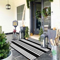 the front porch is decorated for christmas with wreaths and potted trees