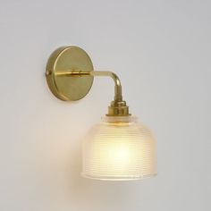 a light that is on the wall next to a white wall with a glass shade