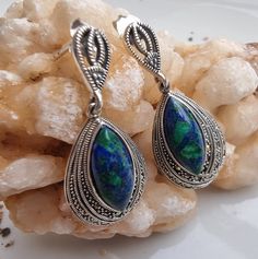 These luxurious Sterling Silver Earrings features Eilat stone King Solomon Stone. Crafted in a captivating tear-drop shape, these large earrings feature the enchanting Eilat stone, sourced directly from the ancient lands of Israel. The gem's rich green and blue hues evoke the spirit of the region, making each piece a testament to its origin. Set against the backdrop of high-quality sterling silver, these earrings exude regality, reminiscent of King Solomon's grandeur. Intricately adorned with ma Eilat Stone, Blue Opal Necklace, Eilat, King Solomon, Rich Green, Amethyst Pendant, Green Gemstones, Large Earrings, Opal Necklace