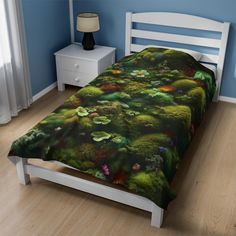 a bed in a bedroom with blue walls and wooden flooring that has a green bedspread on it