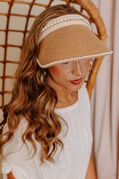 Stay protected from the sunshine while also staying stylish with this adorable tan visor featuring lightweight raffia material with delicate pearl trim detailing, an oversized brim, and an adjustable back! Spring Brimmed Visor With Upf 50+, Spring Upf 50+ Brimmed Visor, Chic Straw Visor Sun Hat, Elegant Spring Visor Sun Hat, Brown Summer Visor Sun Hat, Brown Summer Visor Straw Hat, Brown Visor Sun Hat For Summer, Chic Straw Visor Hat, Brown Visor Straw Hat For Summer