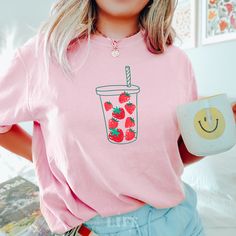 Pour yourself into style with our deliciously adorable Strawberry Shirt! Perfect for granola girls who love to add a splash of fruitiness to their wardrobe or anyone looking to sweeten up their look for the next fruit festival. This tee, featuring vibrant strawberries tumbling into a cup, makes the perfect gift for your best friend or any fabulous fruit lover in your life. Grab this berry special tee and let the good times and juices flow! Colors may appear slightly different in person versus on Fruit Festival, Clothing Kawaii, Foodie Outfit, Brunch Shirts, Strawberry Gifts, Garden Shirt, Fruit Shirt, Strawberry Shirt, Girls Brunch