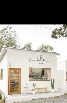 a small white building sitting on top of a gravel road