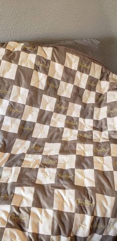 a brown and white checkered blanket sitting on top of a bed