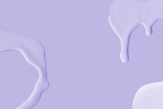 two white icing swirls on a purple background, one is melting and the other is drizzled