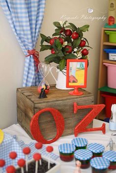 a table topped with cupcakes covered in blue and red frosting next to a vase filled with flowers