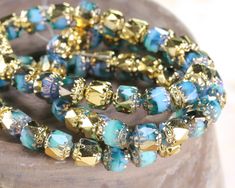 Dive into the depths of these stunning beads, reminiscent of sun-dappled aquamarine waters. Each bead is a treasure, meticulously crafted by expert artisans from the Czech Republic. The radiant gold accents on the surface add a touch of elegance and richness, enhancing the captivating interplay of colors. With their 6mm size, these beads are perfect for ladderstitch bracelets. Czech glass beads are known for their sparkling cuts and vibrant colors. The art of glassmaking dates back to Roman time Gold Lanterns, Beads Online, Bead Store, Czech Glass Beads, Gold Accents, Czech Republic, Czech Glass, Aquamarine, Gemstone Beads