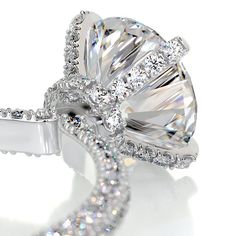 a diamond ring is shown on a white surface with diamonds surrounding it and the band