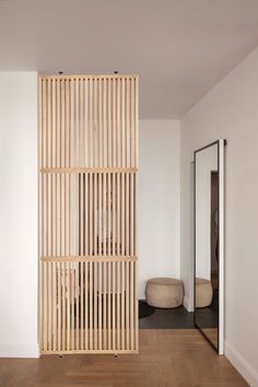 a room divider made out of wooden slats in front of a white wall