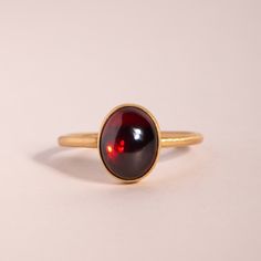 A delicious ring, set in 18k gold with a slick, juicy garnet cabochon. Garnet Cluster Ring, Yellow Gold Garnet Signet Ring With Gemstone, Yellow Gold Garnet Ring With Polished Finish, Red Domed Gemstone Rings, Classic Garnet Rings With Bezel Setting, Timeless Cabochon Sapphire Ring Gift, Timeless Gift Sapphire Cabochon Ring, Elegant Amber Cabochon Ring, Classic Garnet Birthstone Ring In Yellow Gold