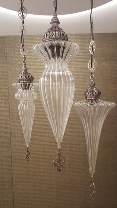 three glass lamps hanging from a ceiling in a room