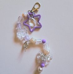 two charms with beads on them sitting next to each other, one has a star and the other is a bead