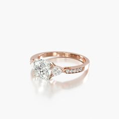 a rose gold engagement ring with a pear shaped diamond in the center and side stones